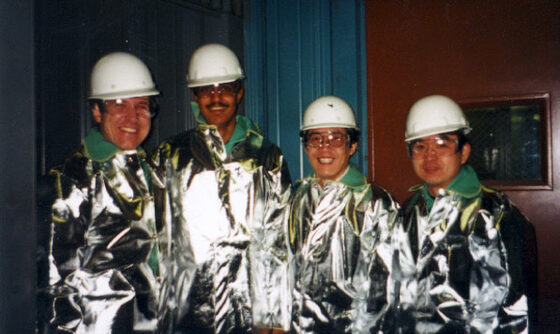 People in heat-protective suits on the plant floor